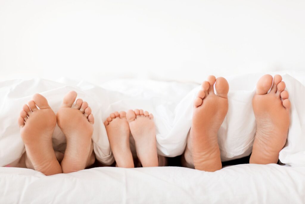 voeten van gezin in een bed
